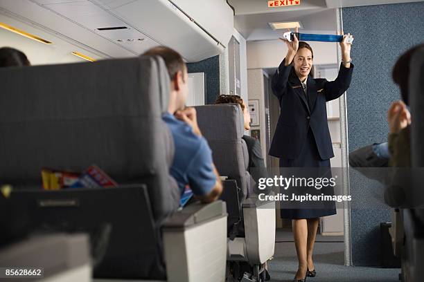 stewardess explaining safety procedures to passengers on airplane - seat belt stock pictures, royalty-free photos & images