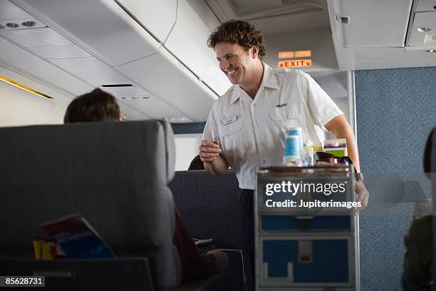 steward serving passengers on airplane - steward stockfoto's en -beelden