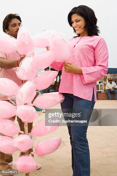 woman buying cotton candy from vendor, india - kurta stockfoto's en -beelden