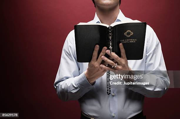 man holding rosary and bible - cristianismo imagens e fotografias de stock