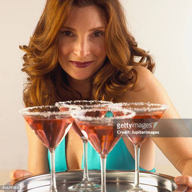 smiling woman with tray of cocktails - einzelne frau über 30 stock-fotos und bilder
