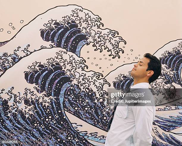 man standing near mural of waves - katsushika hokusai stock pictures, royalty-free photos & images