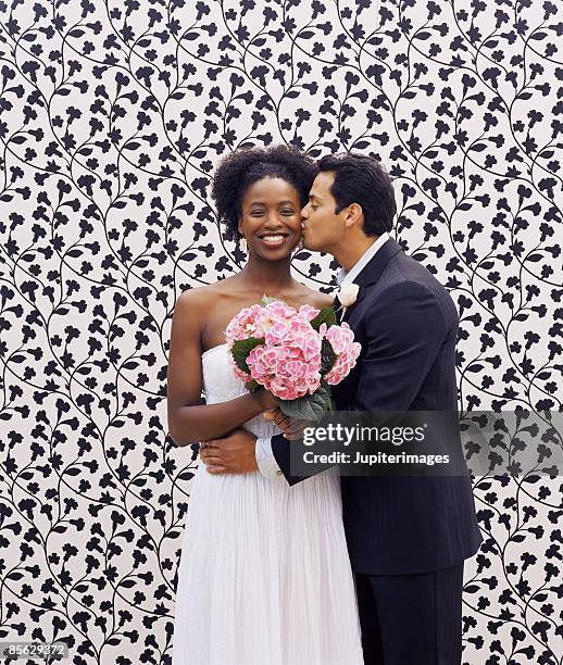 man kissing woman on cheek - bride and groom looking at camera stock-fotos und bilder