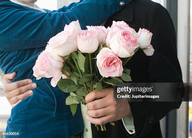 couple with and bouquet of roses - giving flowers stock pictures, royalty-free photos & images