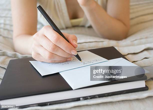 woman writing on stationery - correspondence stockfoto's en -beelden
