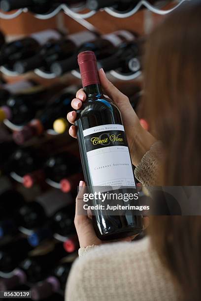 woman holding bottle of wine - flaschenpost stock-fotos und bilder