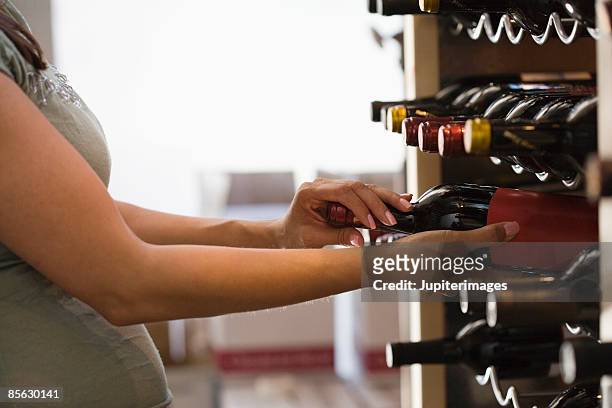 pregnant woman shopping for wine - cellier photos et images de collection
