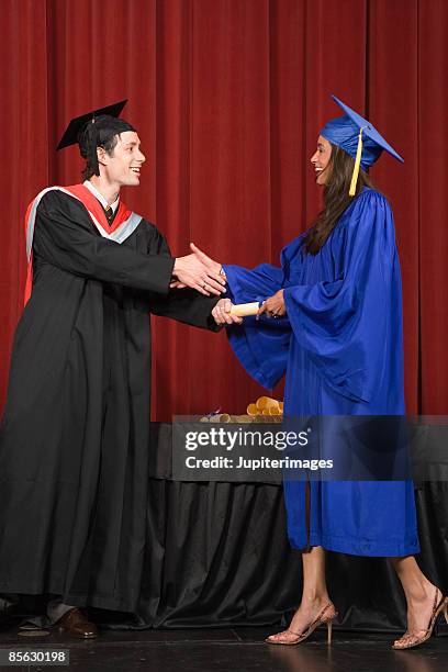 woman receiving diploma on stage - graduation podium stockfoto's en -beelden