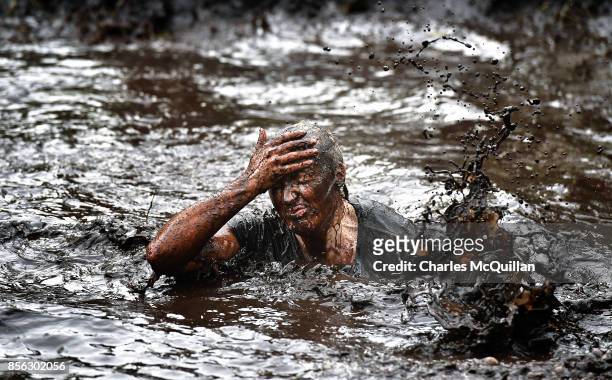Runner grimaces as she makes her way through a mud pit during the McVities Jaffa Cakes Mud Madness race in association with charity partner Marie...