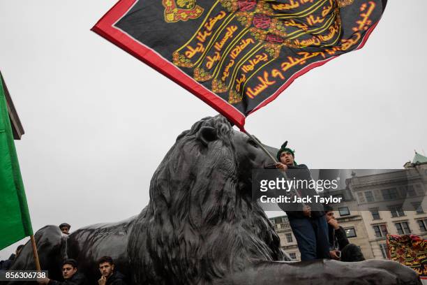 Young man waves a flag in Trafalgar Square following the annual Ashura march on October 1, 2017 in London, England. Thousands of protesters march...