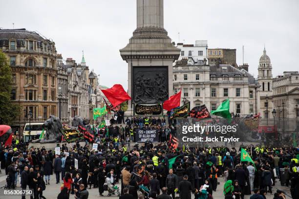 Muslims gather with banners and flags to listen to a speaker in Trafalgar Square following the annual Ashura march on October 1, 2017 in London,...