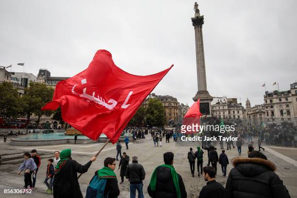 Protesters carry flags as they arrive in Trafalgar Square during the annual Ashura march on October 1, 2017 in London, England. Thousands of...
