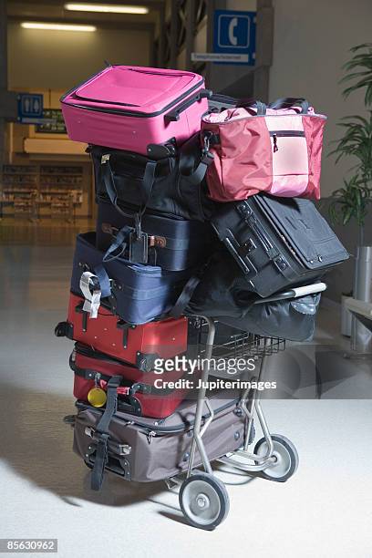 luggage stacked on luggage cart - luggage trolley stockfoto's en -beelden
