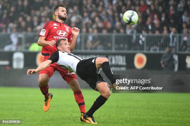 Lyon's French midfielder Lucas Tousart vies with Angers's Algerian defender Mehdi Tahrat during the French L1 football match between Angers and Lyon...