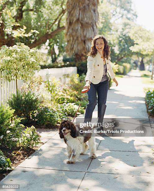 happy woman walking her dog - happy lady walking dog stockfoto's en -beelden
