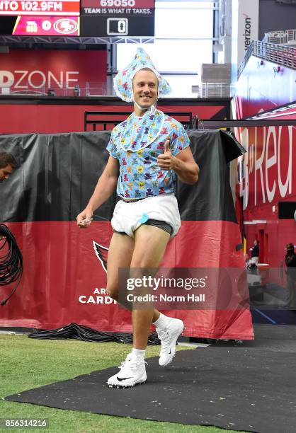 Blaine Gabbert of the Arizona Cardinals takes the field while wearing a baby costume prior to a game against the San Francisco 49ers at University of...