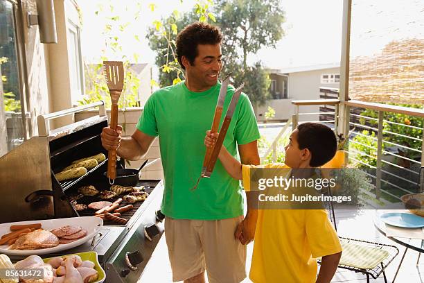 father and son barbecuing - dad bbq stock pictures, royalty-free photos & images