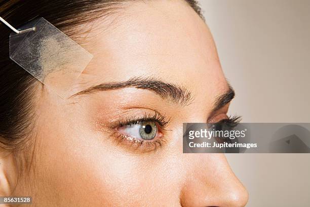 woman with sking on forehead stretched - chirurgie esthétique photos et images de collection