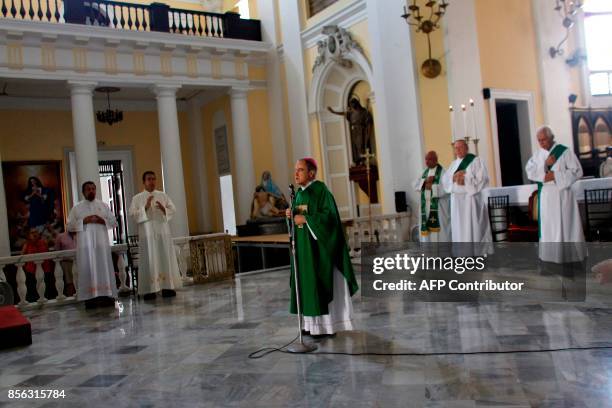 Archbishop Roberto Gonzalez prays with other priests during Sunday Mass in the San Juan Cathedral in San Juan, Puerto Rico on October 1, 2017.While...