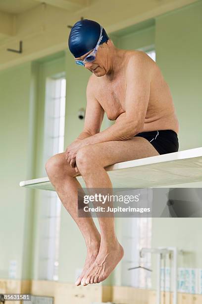 man sitting on diving board - diving board stock pictures, royalty-free photos & images