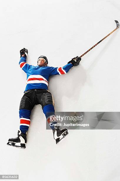 hockey player lying down on ice - skate fail stock-fotos und bilder