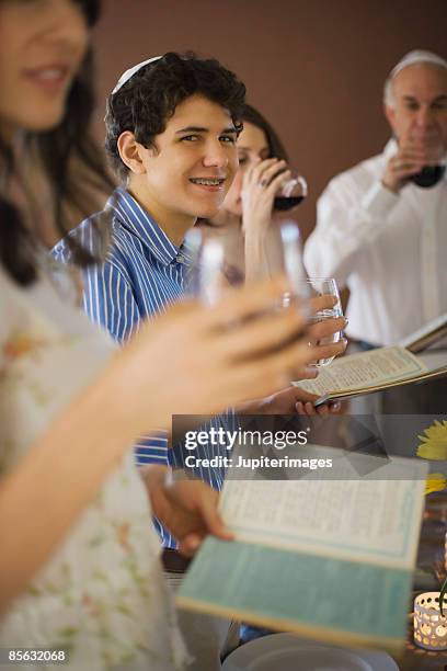 family reading out of the torah and drinking wine - pessach stock-fotos und bilder