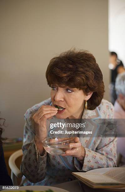 woman eating karpas - karpas stockfoto's en -beelden