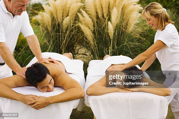 couple receiving massages - massage couple stock pictures, royalty-free photos & images