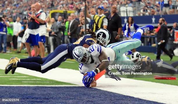 Ezekiel Elliott of the Dallas Cowboys dives into the end zone to score a touchdown against Mark Barron of the Los Angeles Rams in the second quarter...