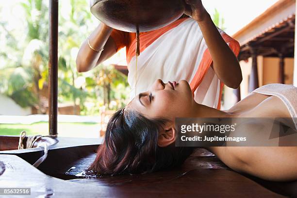 woman receiving shirodhara therapy - ayurveda stock-fotos und bilder