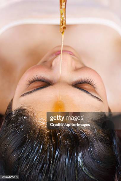 woman receiving shirodhara therapy - shirodhara stock pictures, royalty-free photos & images