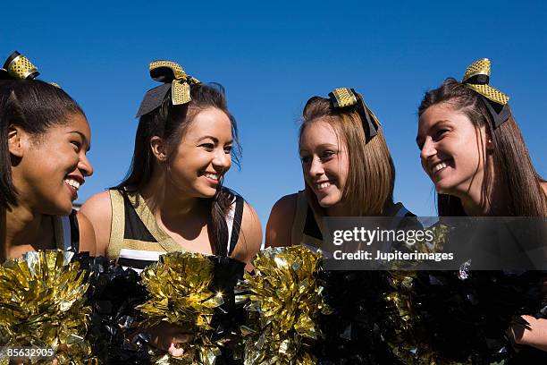 smiling cheerleaders - cheerleader stock pictures, royalty-free photos & images