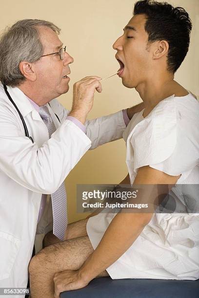 doctor examining patient - tongue depressor stock pictures, royalty-free photos & images