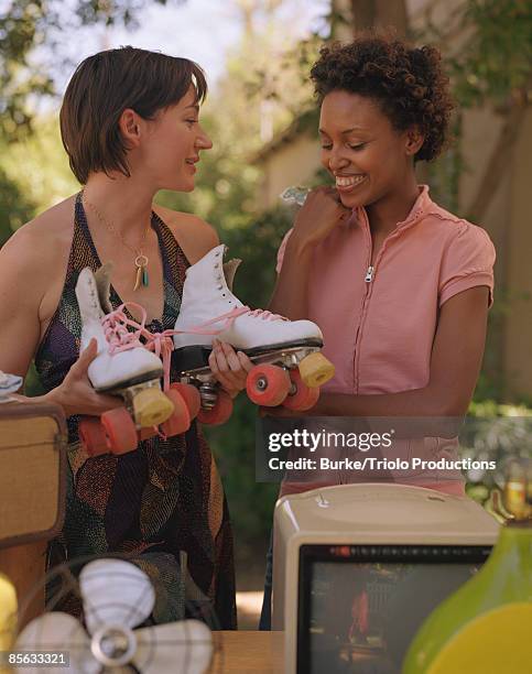 women at yard sale holding roller skates - ガレージセール ストックフォトと画像