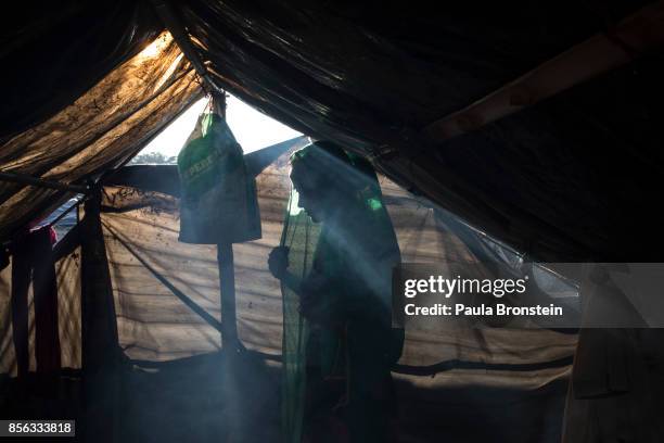 Rohingya woman adjusts her head scarf inside a smoky tent October 1, 2017 in Balukhali, Cox's Bazar, Bangladesh. Over a half a million Rohingya...