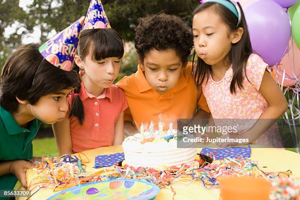 children blowing out candles on birthday cake - chinese birthday stockfoto's en -beelden