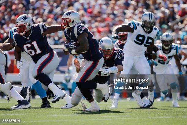 Tom Brady of the New England Patriots falls down after handing off the ball to Mike Gillislee during the first half against the Carolina Panthers at...