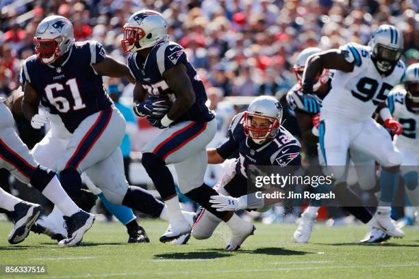 Tom Brady of the New England Patriots falls down after handing off the ball to Mike Gillislee during the first half against the Carolina Panthers at...