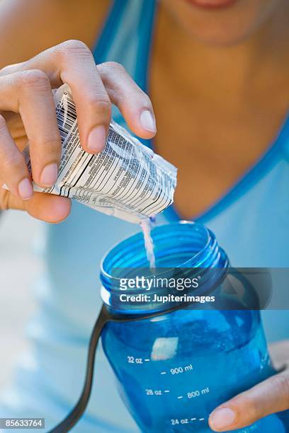 woman mixing beverage with a drink mix - bolsita fotografías e imágenes de stock