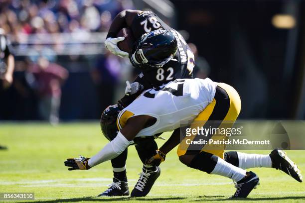 Tight end Benjamin Watson of the Baltimore Ravens is tackled by defensive back J.J. Wilcox of the Pittsburgh Steelers in the first quarter at M&T...