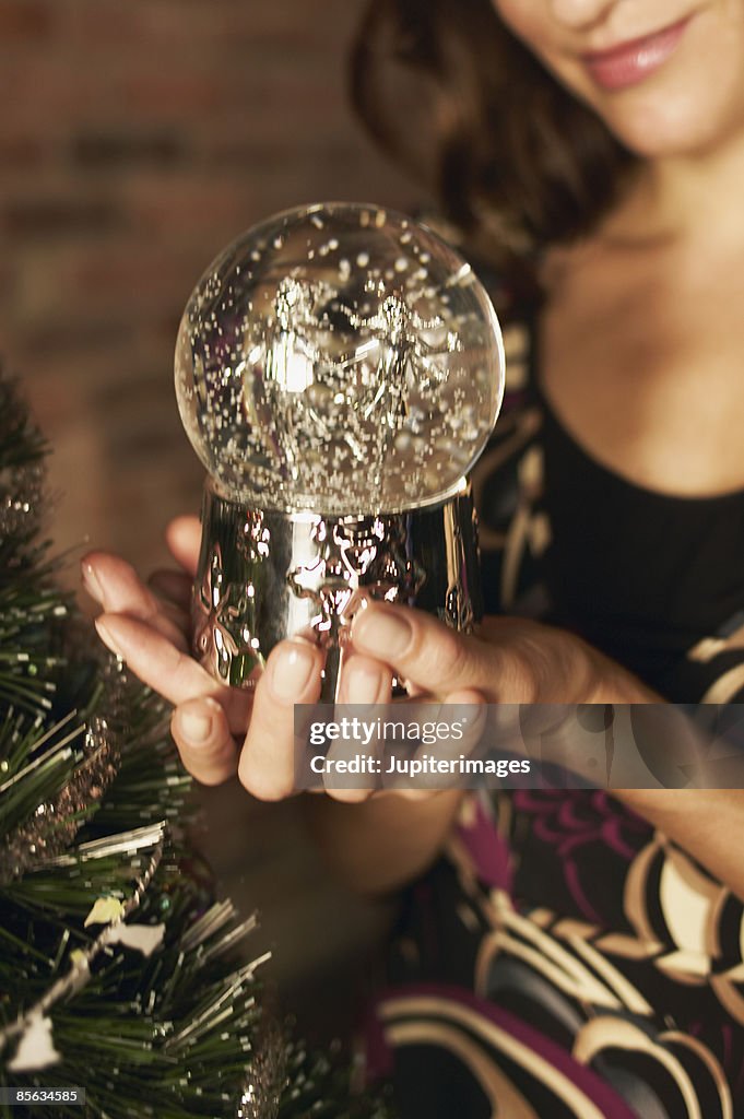 Cropped woman holding snowglobe