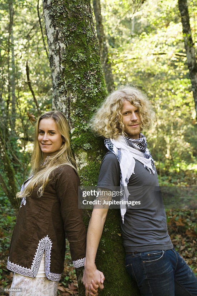 Couple leaning against tree holding hands , Humboldt , California , USA