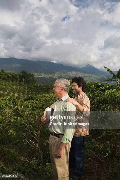 father and son looking at coffee plantation , colombia - south america farm stock pictures, royalty-free photos & images