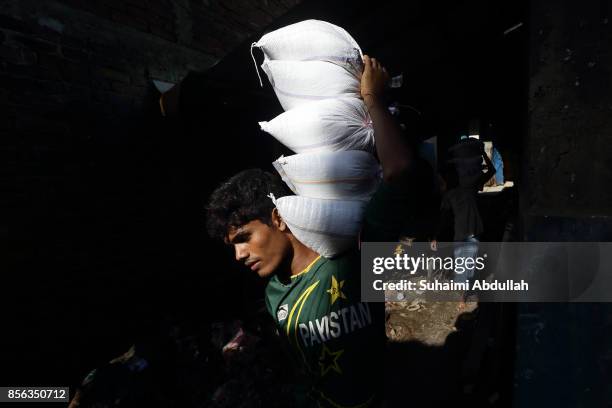 Workers prepare to load up rice sacks for food distribution for Rohingya refugees on September 30, 2017 in Cox's Bazar, Bangladesh. Over 430,000...