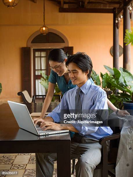man and woman using laptop computer - vietnamese culture 個照片及圖片檔