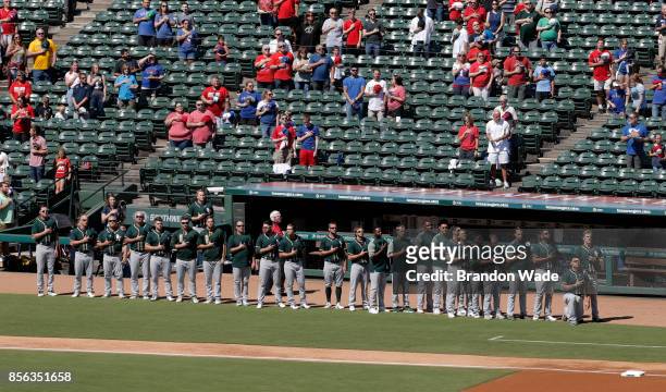 Catcher Bruce Maxwell of the Oakland Athletics kneels during the playing of the National Anthem before a baseball game against the Texas Rangers at...
