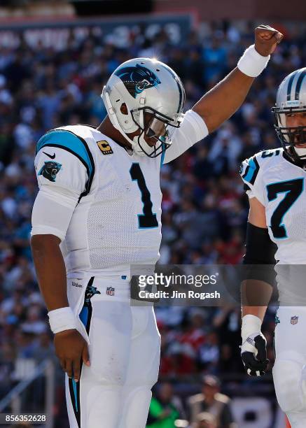 Cam Newton of the Carolina Panthers raises his fist in the end zone after scoring a touchdown during the fourth quarter against the New England...