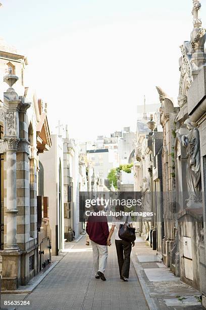 back view of couple walking, la recoleta cemetery, buenos aires, argentina - recoleta buenos aires stock pictures, royalty-free photos & images