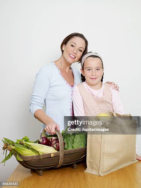 mother and daughter with groceries - トラッグ ストックフォトと画像