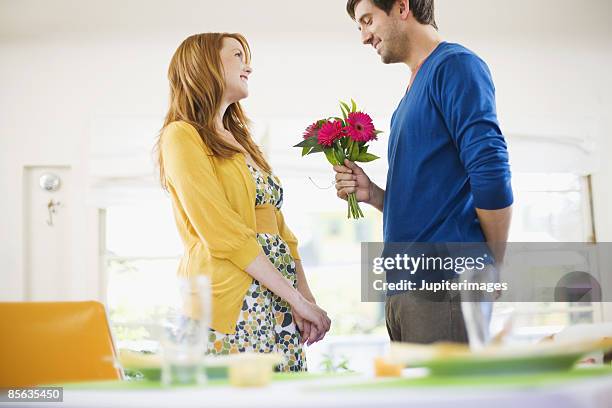 man giving flowers to woman - man giving flowers foto e immagini stock